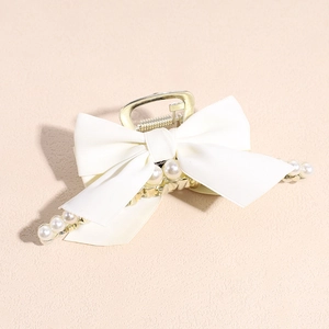 Detail showing elegant cream satin bow and white faux pearls on golden alloy hair claw
