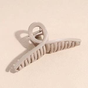 Dettaglio molletta per capelli beige con design a torsione e molla metallica interna