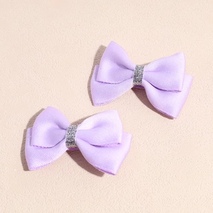 Vue détaillée de barrettes à nœuds en satin violet avec centre ruban argenté