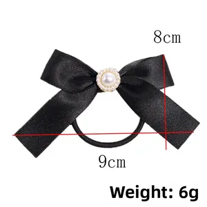 Detail view of black satin bow hair tie with pearl ornament and 9cm size dimensions