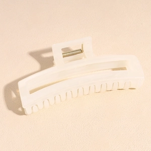 Close-up of cream acetate claw clip with durable metal spring and jagged teeth