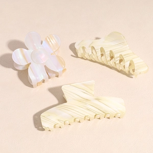 Three-piece acetate hair claw set with pearlescent flower and marble texture patterns