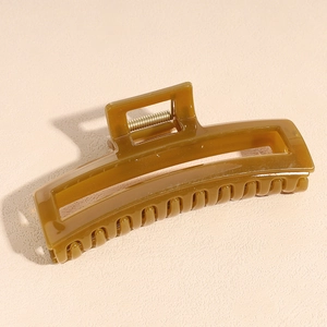 Detail of large amber acetate hair claw clip with rectangular cutout and strong metal spring