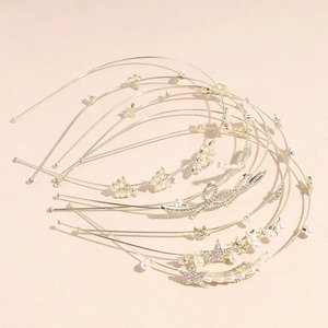 Détail de serre-têtes dorés avec perles, strass et breloques en lettres Love