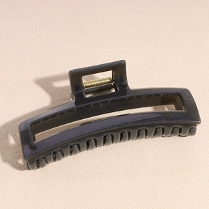 Detail of grey acetate hair claw clip showing shiny texture and strong metal spring