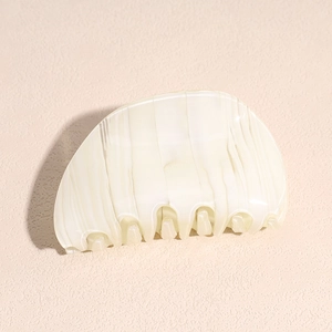 Close-up of cream white marble acetate hair claw clip with pearlescent glossy texture