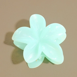 Détail de la pince à cheveux en forme de fleur vert menthe avec finition brillante
