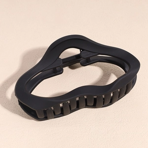 Macro shot of matte black wavy hair claw clip showing durable spring and anti-slip teeth