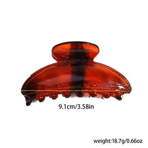 Detail view of amber translucent hair claw clip with dimensions 9.1cm and 18.7g weight