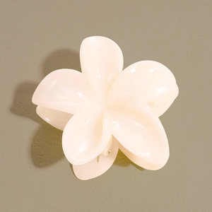 Vue détaillée de dessus d'une pince à cheveux fleur de frangipanier couleur crème