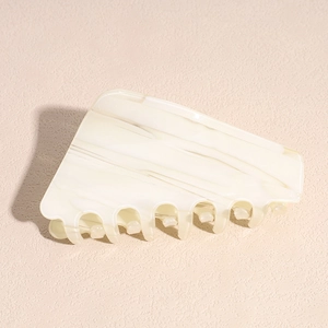 Detailed macro view of cream white marbled acetate hair claw with high-quality grip teeth