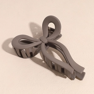 Detail view of mocha brown matte bow hair claw clip with sturdy metal spring