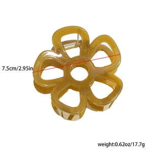 Detail view of flower hair claw clip showing 7.5cm diameter and amber resin material
