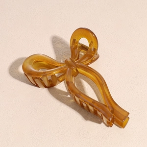Détail d'une grande pince à cheveux nœud ambre avec une finition translucide élégante