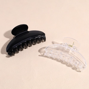 Minimalist curved hair claw clips set in glossy black and transparent acrylic finishes