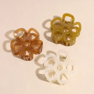 Three hollow floral hair claws in brown, amber, and cream white colors for women