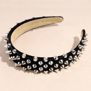 Détail d'un serre-tête punk noir large avec trois rangées de rivets à pointes argentées
