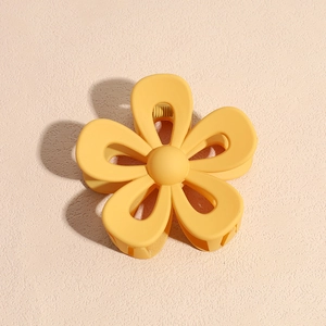 Dettaglio di un fermaglio per capelli a forma di fiore giallo opaco in resina satinata