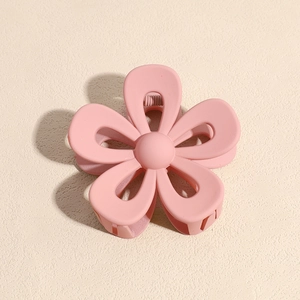 Dettaglio della molletta per capelli a fiore rosa opaco con molla in metallo e denti
