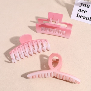 Three gradient pink matte hair claws in rectangular, crescent and twisted styles