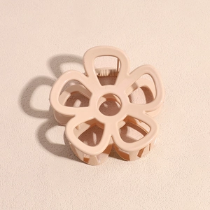 Close-up of a nude pink flower hair claw clip with a glossy finish and metal spring mechanism