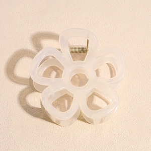 Detail view of a cream white flower hair claw clip with a strong gold metal spring mechanism