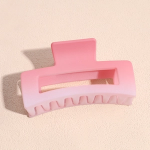 Detail of pink gradient matte claw clip with elegant square hollow design for hair styling