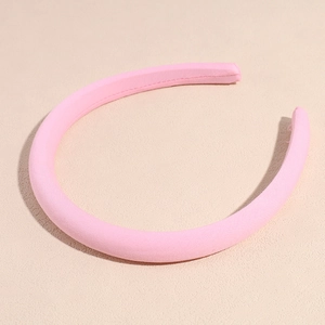 Dettaglio del cerchietto imbottito rosa in spugna con trama in tessuto e finiture cucite