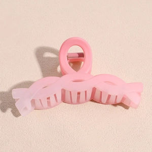 Close-up of pink gradient matte claw clip with sleek curved lines for hair styling