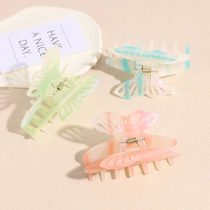 Three gradient butterfly hair claws in pink, blue, and yellow-green resin with metal springs