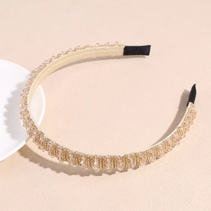 Close-up of champagne crystal headband with sparkling rhinestones and ribbon wrap