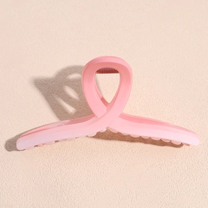 Close-up of pink gradient matte hair claw clip with a minimalist twisted design and jagged teeth