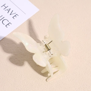Macro shot of butterfly hair claw clip in iridescent pearly beige with metal spring