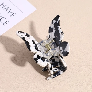 Macro detail of butterfly hair claw clip with black and white marble acetate patterns
