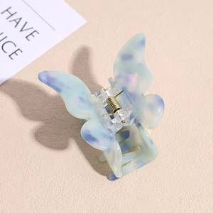 Detail of blue and purple butterfly hair claw clip with marble texture and metal spring