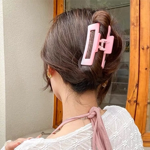 Pink gradient hollow hair claw clip for women styled on dark brown hair in soft lighting