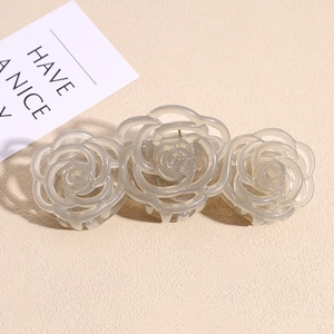 Macro view of translucent rose flower hair claw with three matte grey-pink resin blooms
