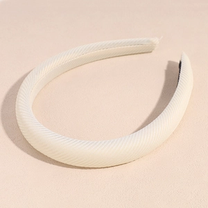 Detailed texture of a cream-colored padded fabric headband with diagonal twill weave