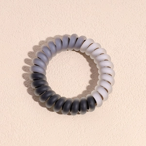 Vue détaillée de l'élastique spirale dégradé mat en noir, gris et blanc épuré