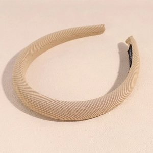 Detail of warm beige padded headband with twill fabric texture and soft side lighting