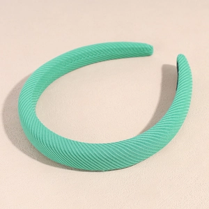 Close-up of mint green fabric headband showing detailed diagonal texture and soft padding