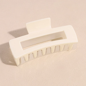 Vue détaillée de la pince à cheveux rectangulaire crème avec un design évidé moderne