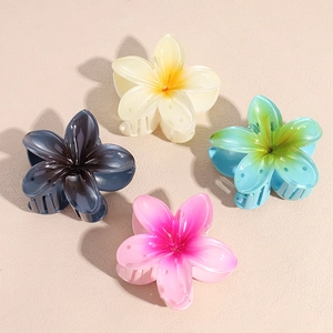 Tropical plumeria flower hair claws in navy, yellow, and gradient candy colors