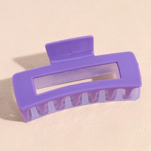 Vue macro d'une pince à cheveux carrée violet foncé avec une finition brillante et dents
