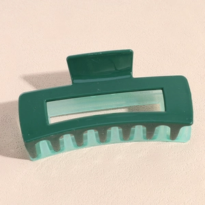 Détail d'une pince à cheveux carrée avec un design bicolore vert foncé et vert clair