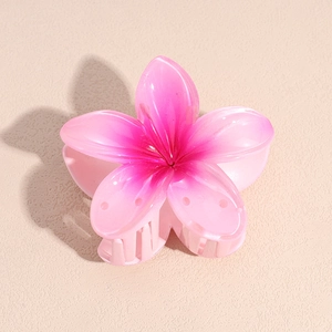 Macro view of pink gradient resin flower hair claw with durable teeth for styling