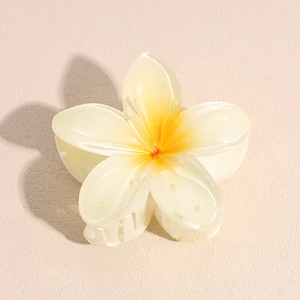 Macro detail of a candy-colored plumeria flower hair claw clip with pearlescent finish