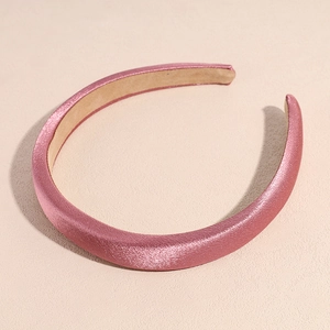 Detail of a lotus pink satin padded headband with a retro sponge high top design