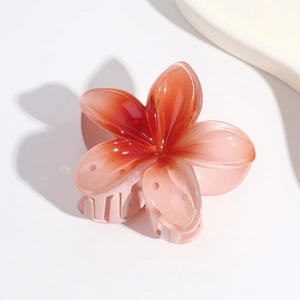 Detail of candy-colored gradient hair claw clip featuring a translucent frangipani flower