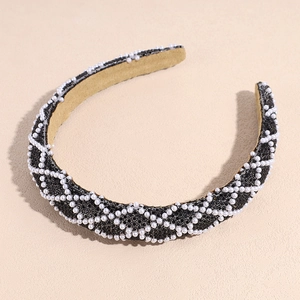 Detail eines breiten schwarzen Haarreifs mit eingelegten Perlen und Strass-Rautenmuster